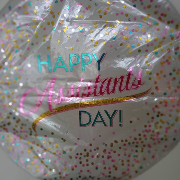 Clear confetti balloon with "Happy Assistant Day" text