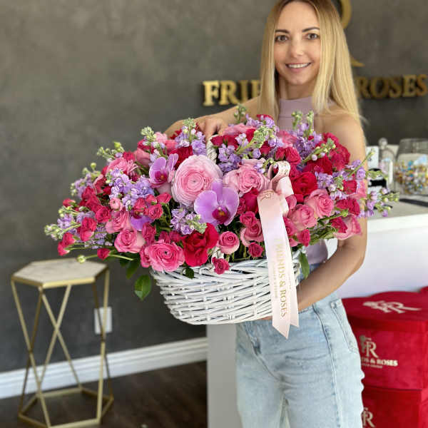 Large basket of pink and purple roses with orchids and ribbon