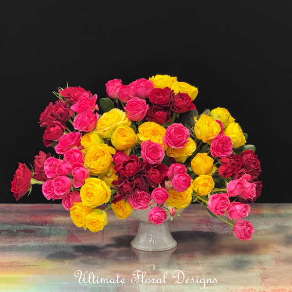 Bouquet of pink, yellow, and red roses in a white vase