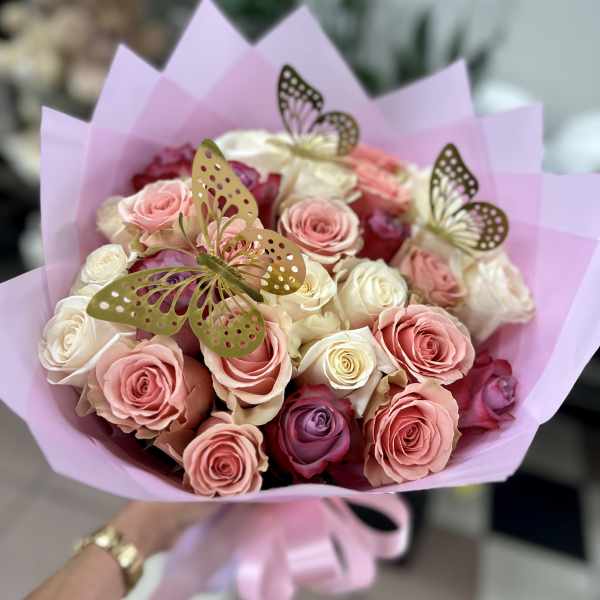 Bouquet of pink and white roses wrapped in lavender paper