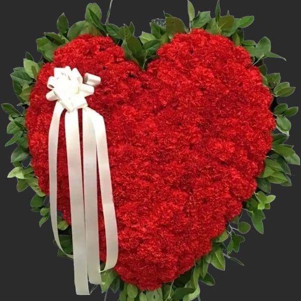 Heart-shaped red floral wreath with a white ribbon bow