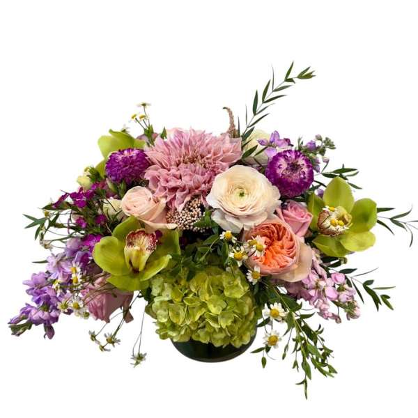 Mixed bouquet in a low black vase with pink, purple, and green blooms