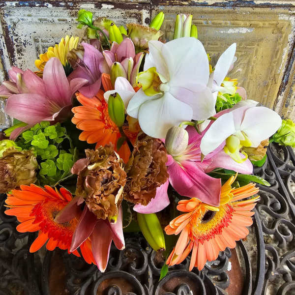 Mixed bouquet with white orchids, pink lilies, and orange gerbera daisies