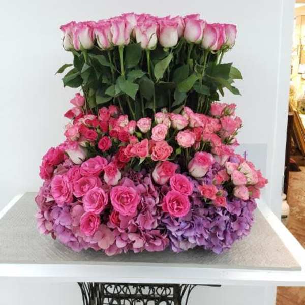 Large pink rose arrangement with hydrangeas on a table