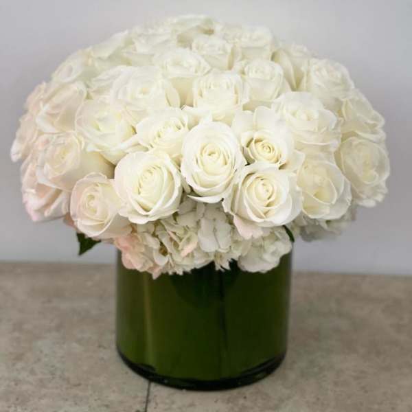 White rose bouquet in a green glass vase
