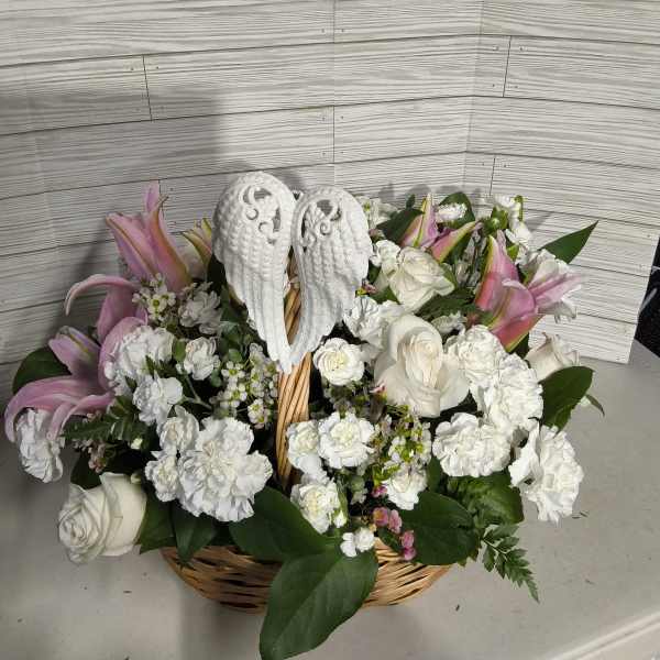 Basket arrangement of white roses, carnations, and pink lilies with angel wings
