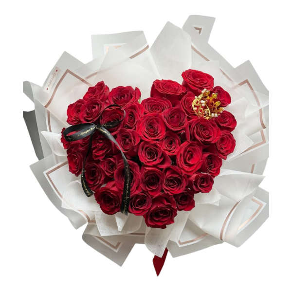 Heart-shaped bouquet of red roses wrapped in white paper