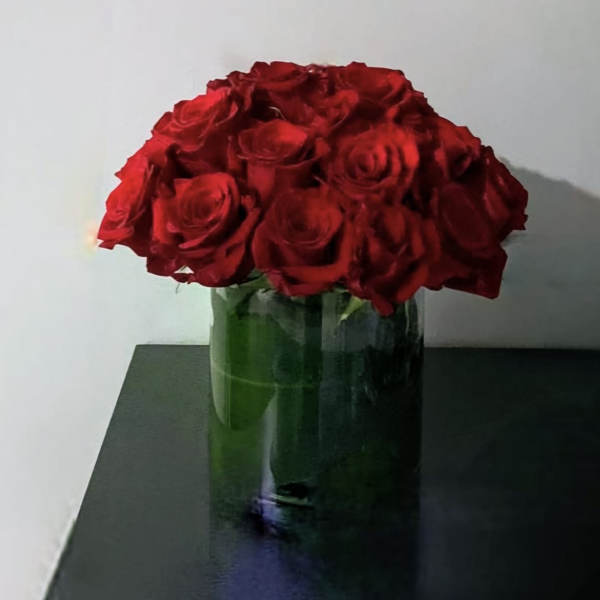 Red roses arranged in a clear glass vase