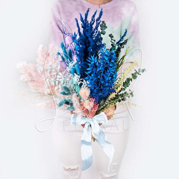 Colorful bouquet with blue and pink dried flowers tied with a ribbon
