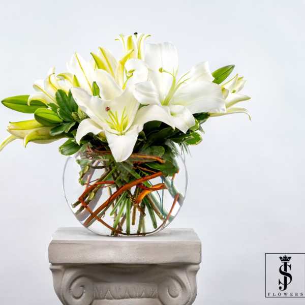 White lilies arranged in a clear glass vase