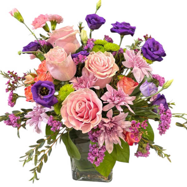 Mixed pink and purple flower arrangement in a clear glass vase