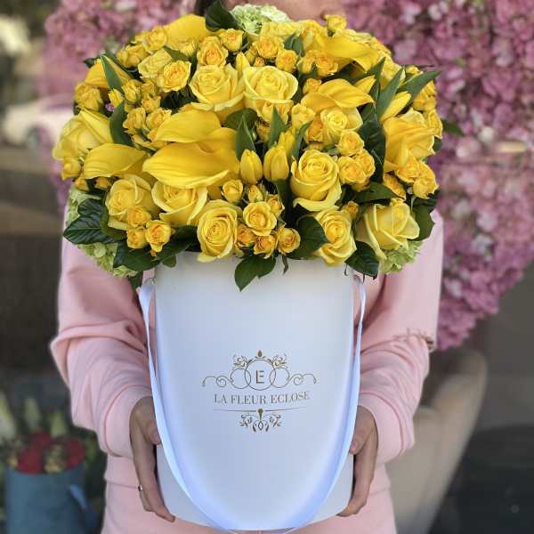 Yellow roses and calla lilies in a white hatbox