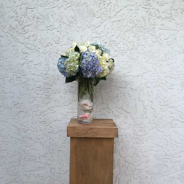Blue and white hydrangea bouquet in a clear glass vase