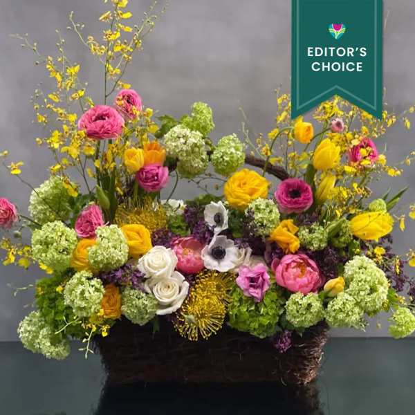 Colorful mixed flower arrangement in a dark basket