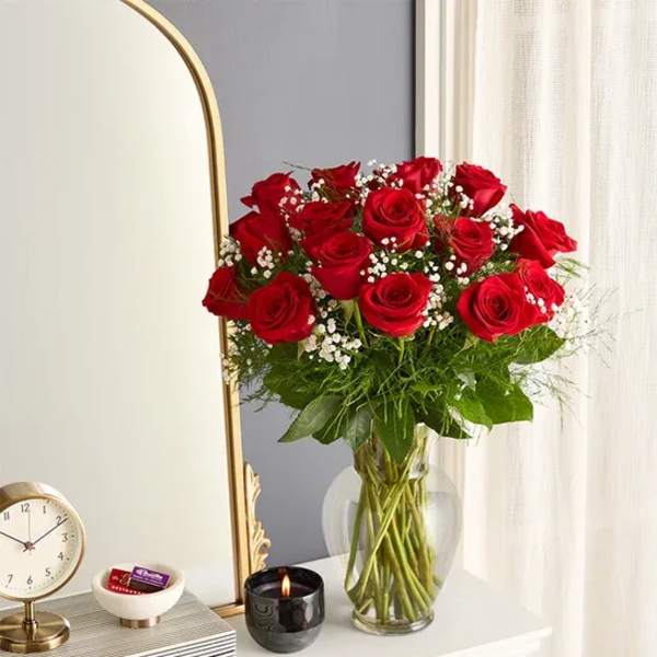Bouquet of red roses in a clear glass vase with baby's breath