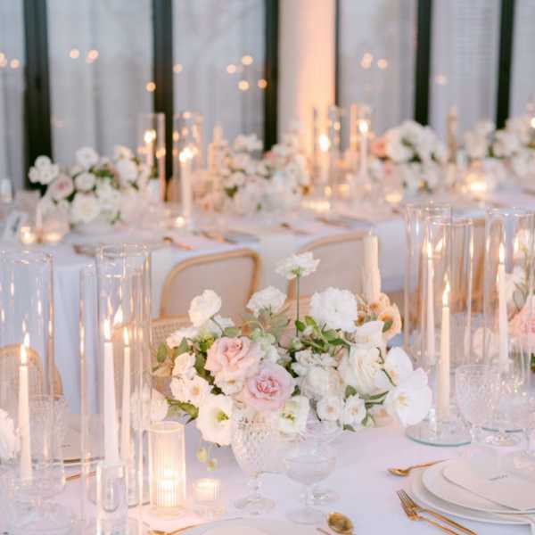 White and blush floral centerpieces on a candlelit banquet table