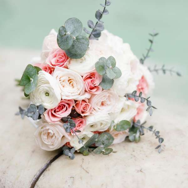 Round bouquet of white and pink roses with eucalyptus
