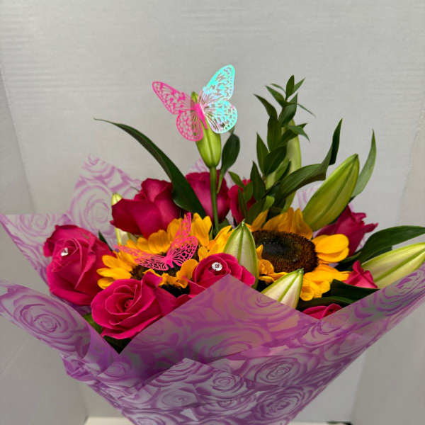 Bouquet of pink roses and yellow sunflowers wrapped in purple paper