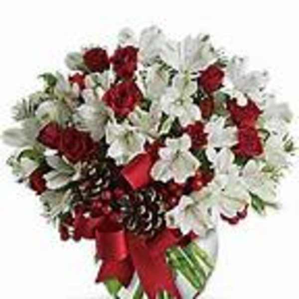 Red roses and white flowers in a glass vase with a red ribbon