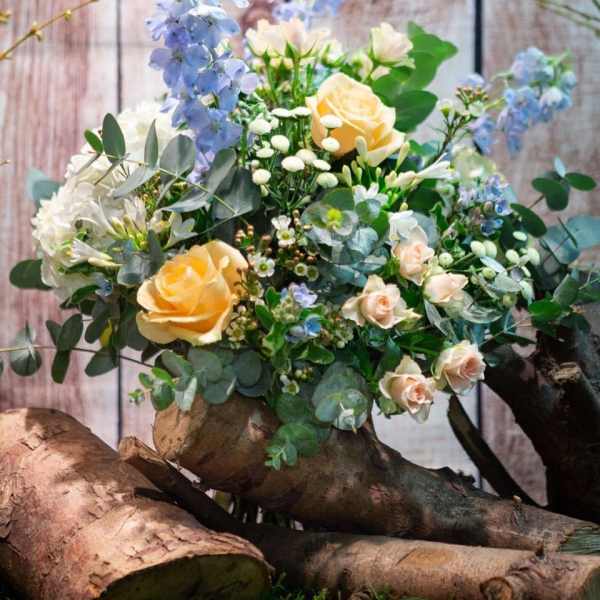 Bouquet of pale yellow roses and blue flowers with eucalyptus