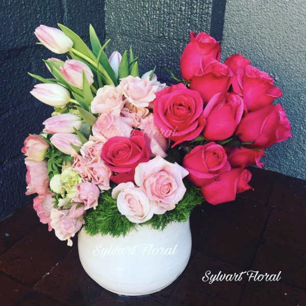 Pink and red roses with tulips in a white vase