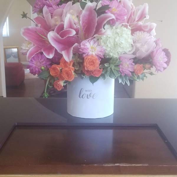Pink lilies and mixed flowers in a white box vase