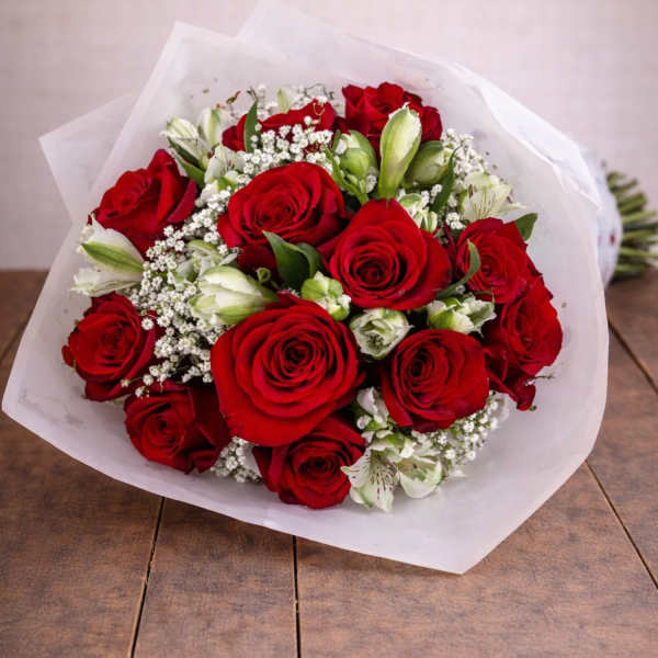 Bouquet of red roses with white filler flowers wrapped in white paper