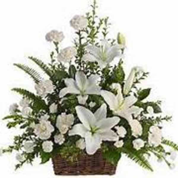 White lilies and carnations arranged in a wicker basket