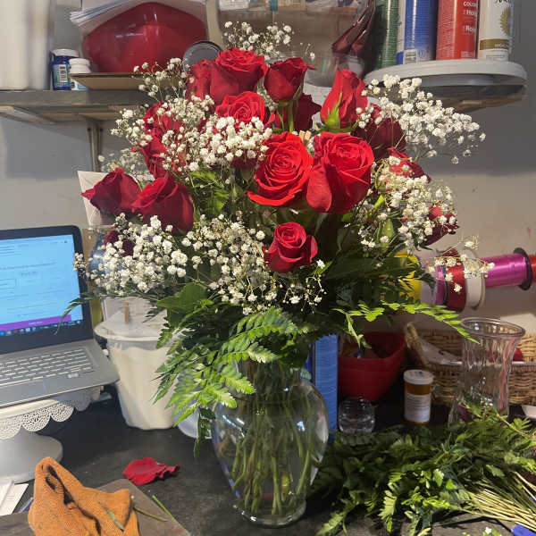 Bouquet of red roses and baby's breath in a glass vase