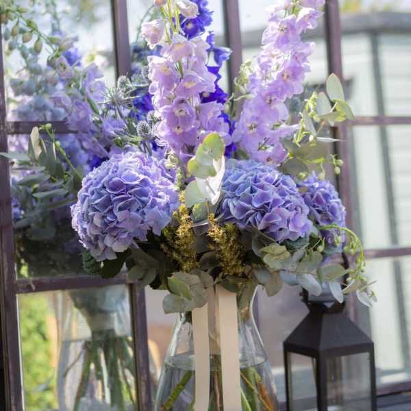 Lavender and blue floral arrangement in a clear glass vase