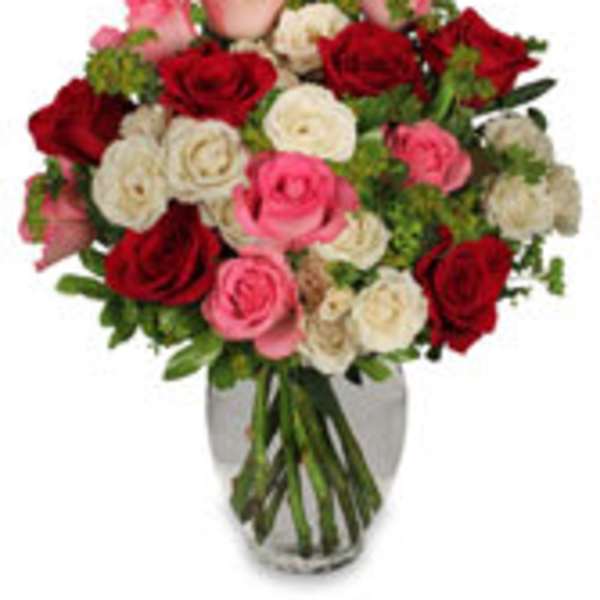 Bouquet of red, pink, and white roses in a clear glass vase