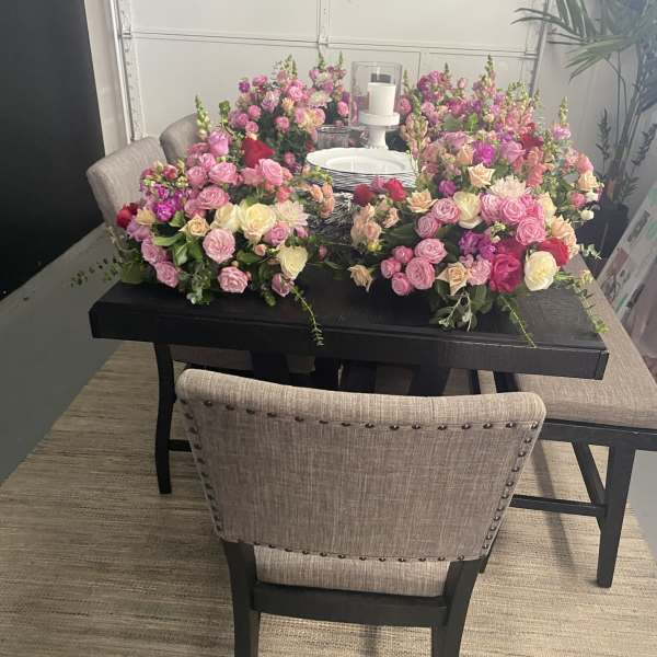 Large pink and cream floral table arrangement with a candle centerpiece