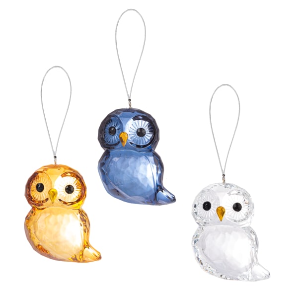 Three owl-shaped glass ornaments in amber, blue, and clear