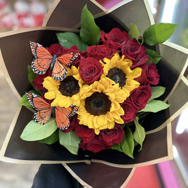 Bouquet of red roses and yellow sunflowers with butterfly picks