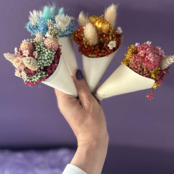 Four small dried flower bouquets wrapped in white paper