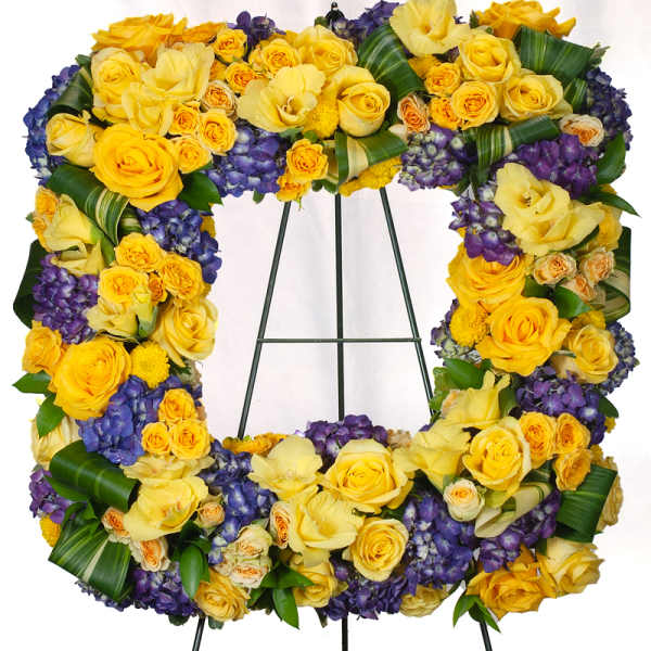 Yellow and purple floral wreath on a metal stand