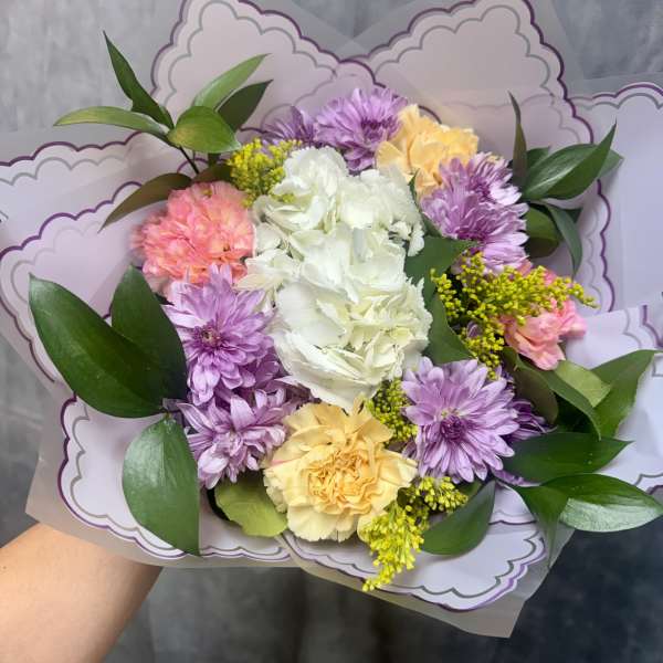 Bouquet of pastel flowers with purple wrapping