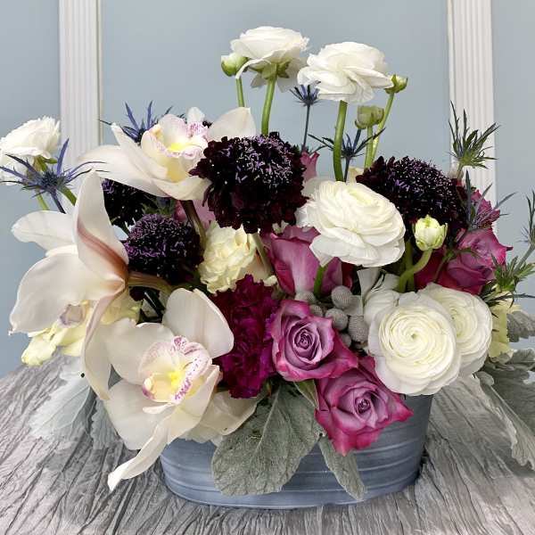 Mixed bouquet in a blue container with white, pink, and purple flowers