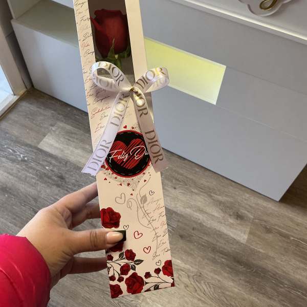 Single red rose in a decorative gift box with a ribbon