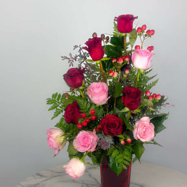 Red and pink roses arranged in a tall vase