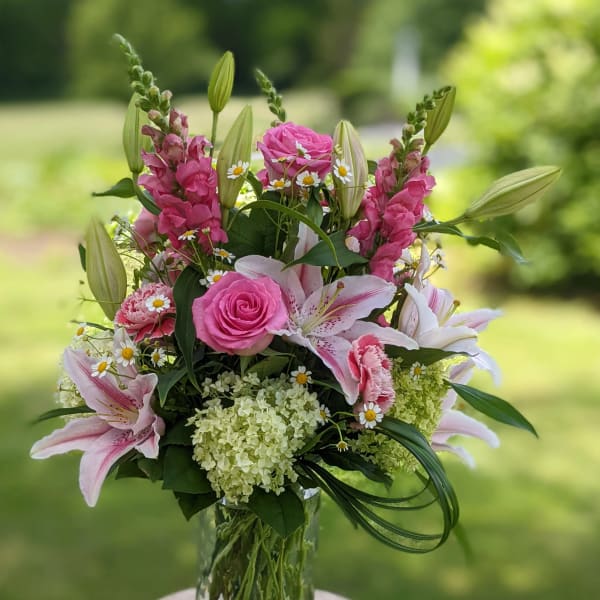 Pink and white floral arrangement in a clear glass vase