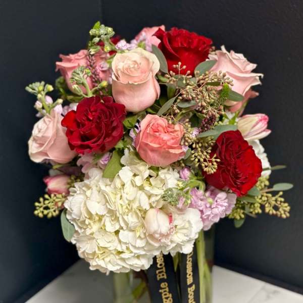 Bouquet of pink and red roses with white hydrangea in a glass vase