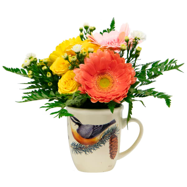 Mixed flowers arranged in a bird-printed mug