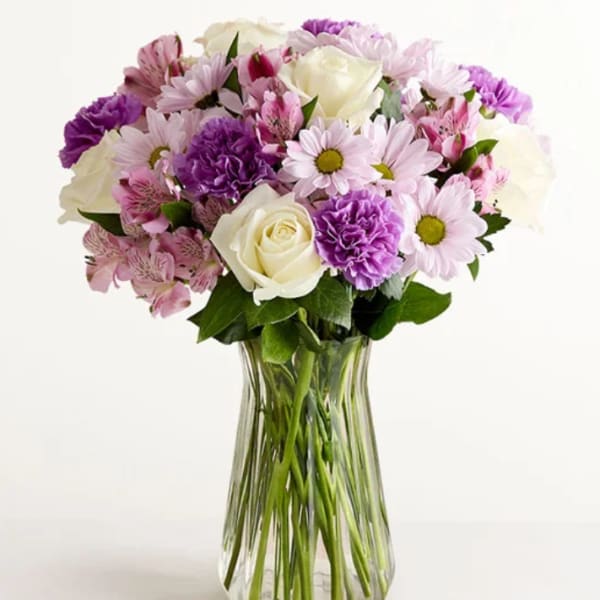 Bouquet of pink and purple flowers in a clear glass vase