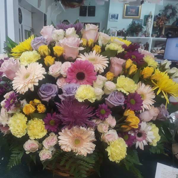 Large mixed bouquet of pastel and bright flowers in a basket