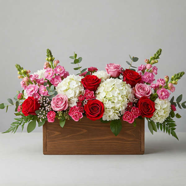 Pink and red roses with white hydrangeas in a wooden box