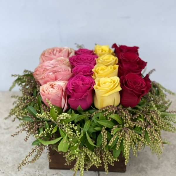 Box arrangement of pink, magenta, yellow, and red roses
