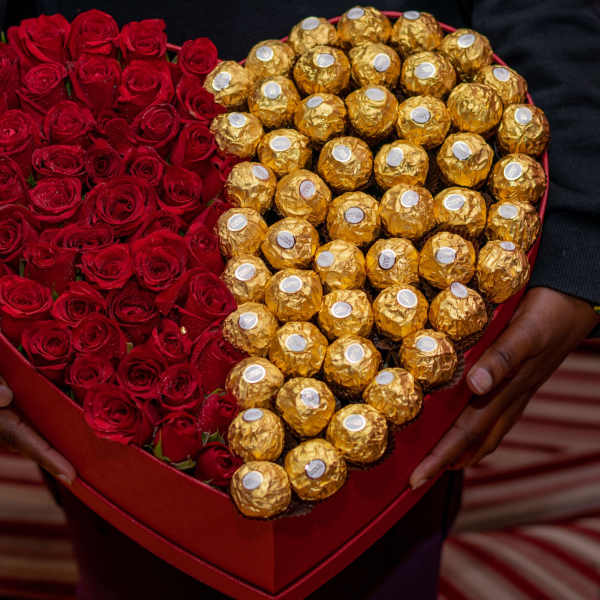 Heart-shaped box of red roses and gold-wrapped chocolates