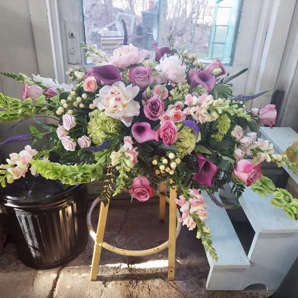 Large floral arrangement with pink and purple blooms on a stand
