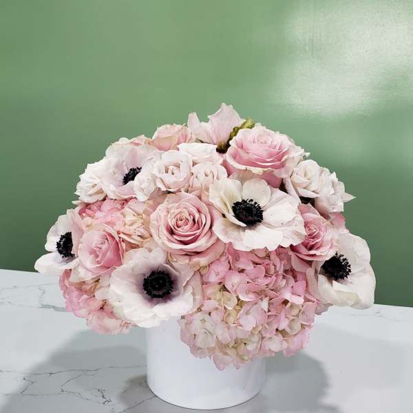 Pink and white floral arrangement in a white vase